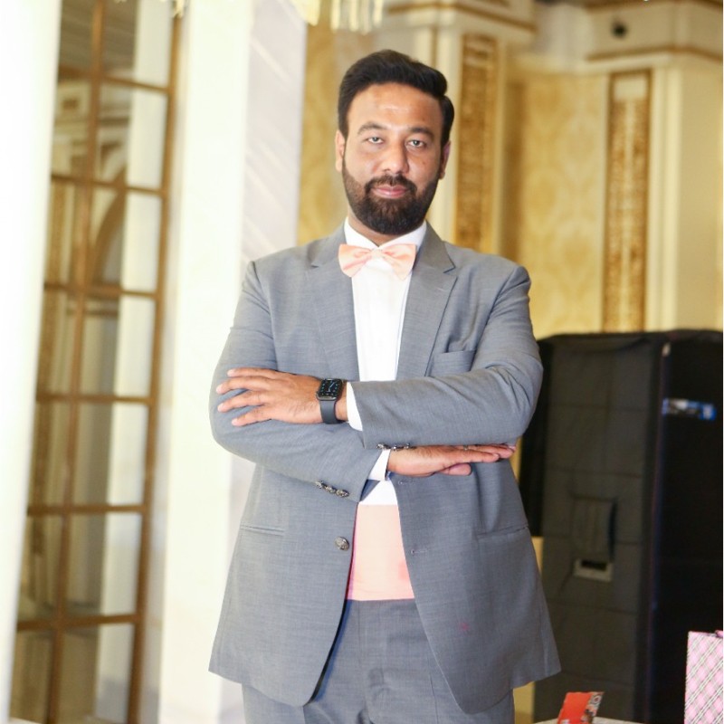 Ahmed Abdullah in a formal gray suit at an event