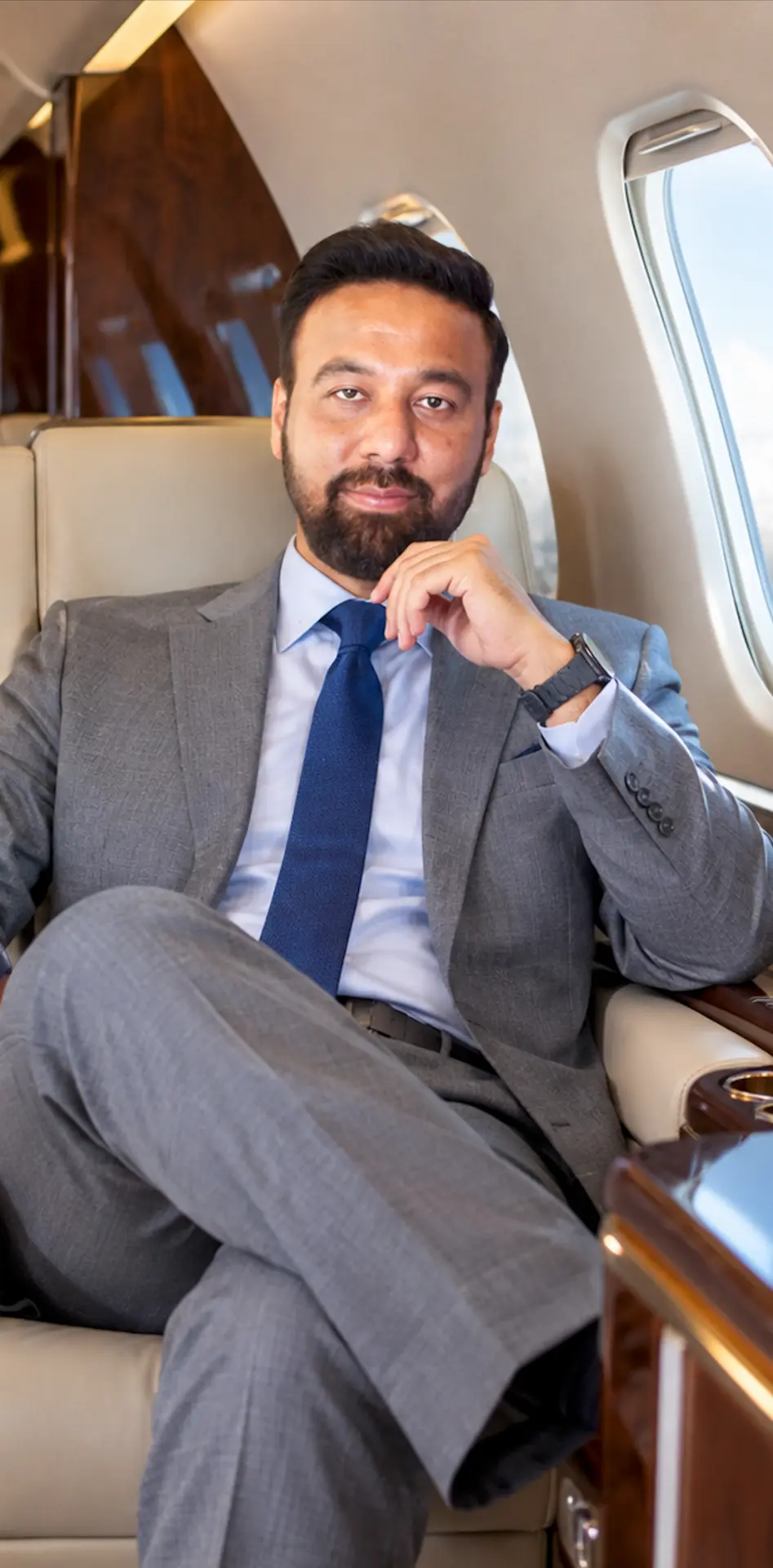 Ahmed Abdullah in a gray suit seated aboard an executive aircraft